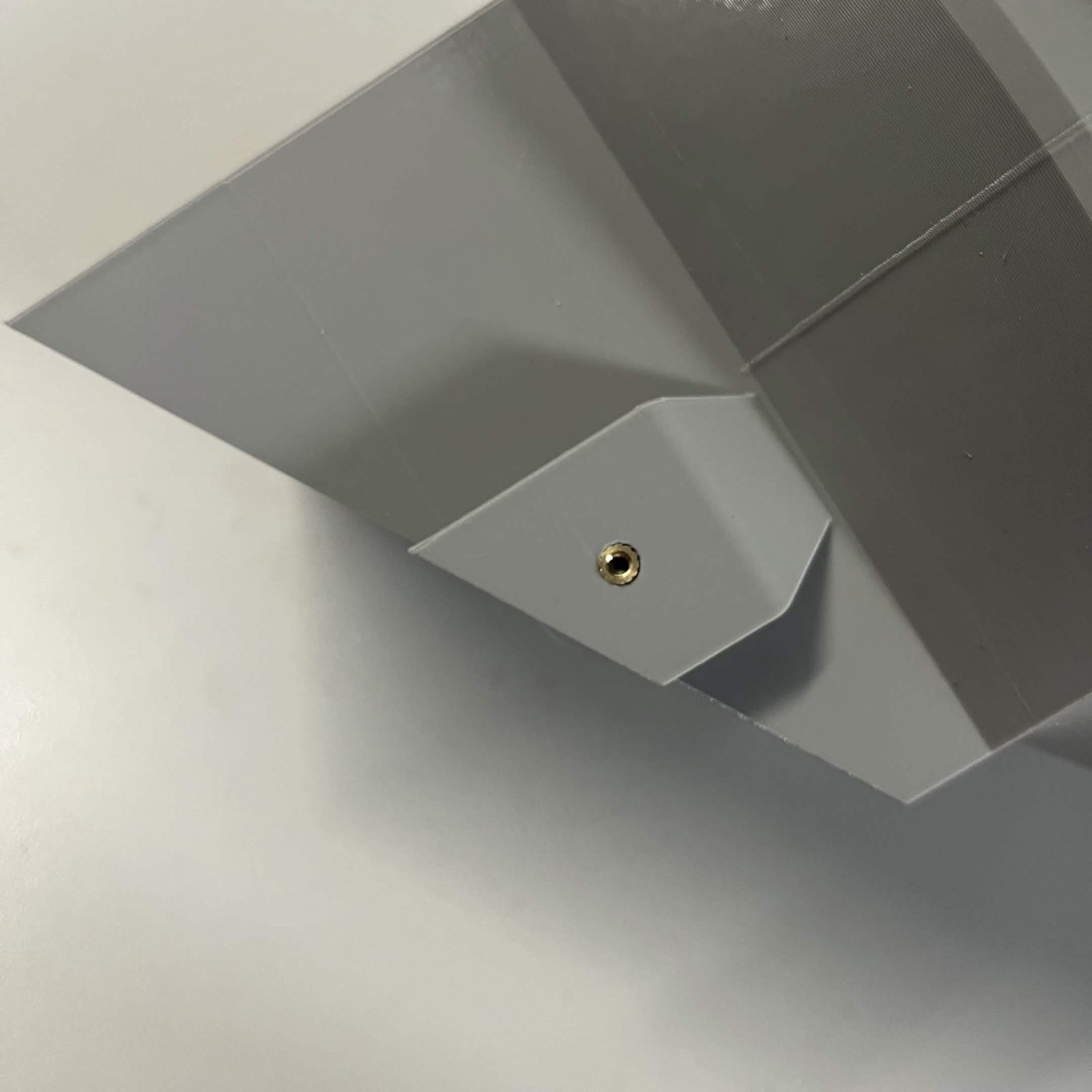 The same raised tab on the chute mount with its brass M3 heat insert pressed in flush