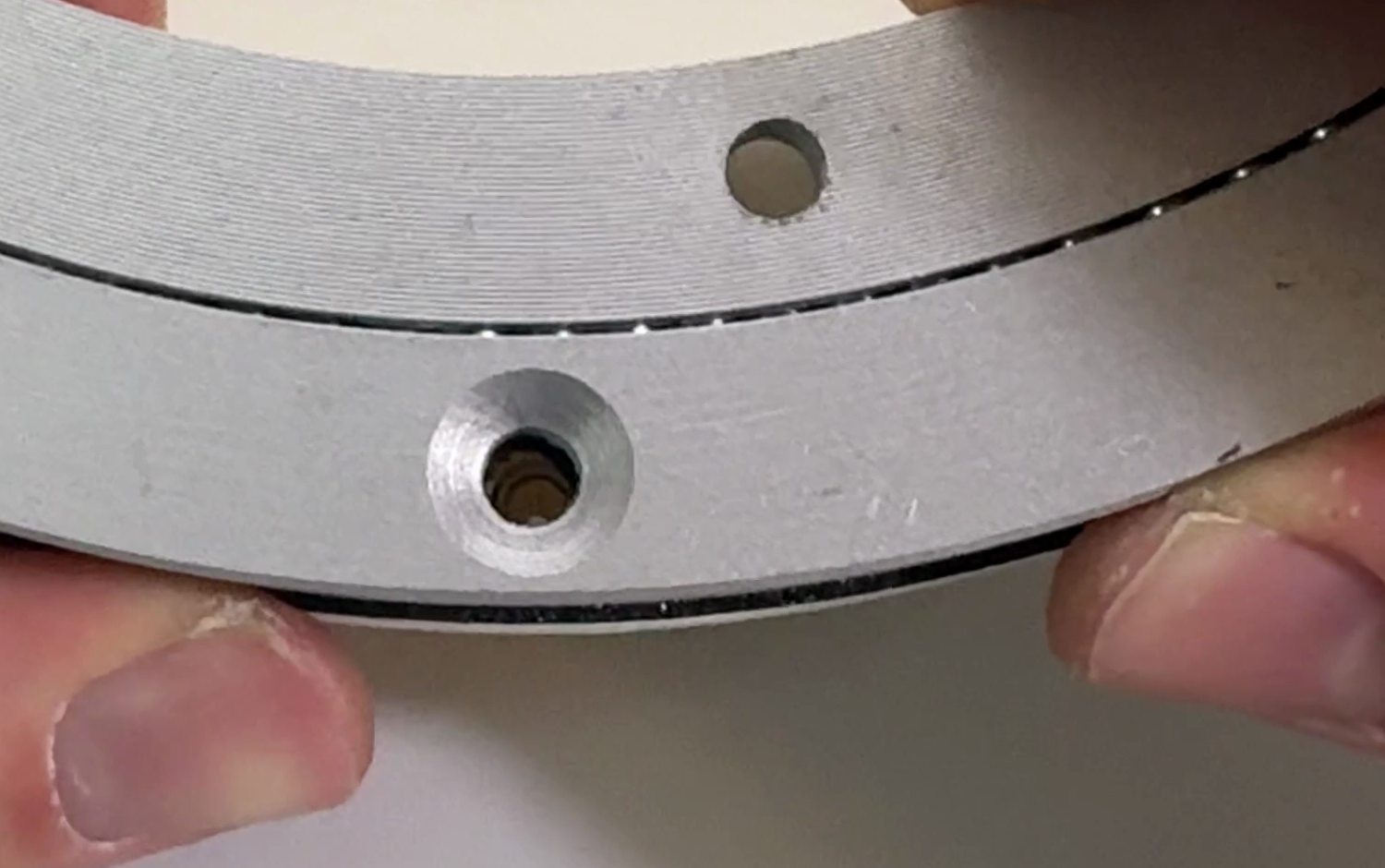 Close-up down an aligned hole in the Lazy Susan, with the brass M4 heat insert in the chute mount visible at the bottom of it