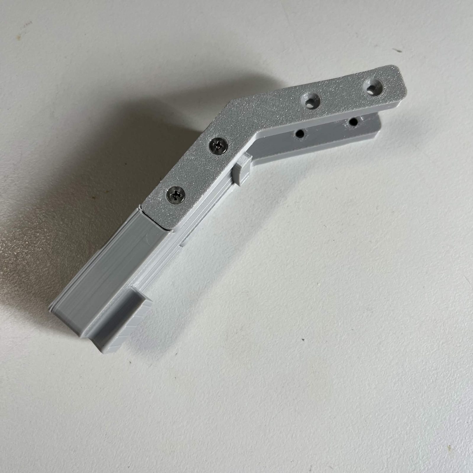 The camera lamp arm butted to its mount with a bracket screwed across the joint, two countersunk screws in it, and the printed dovetail at the far end of the arm