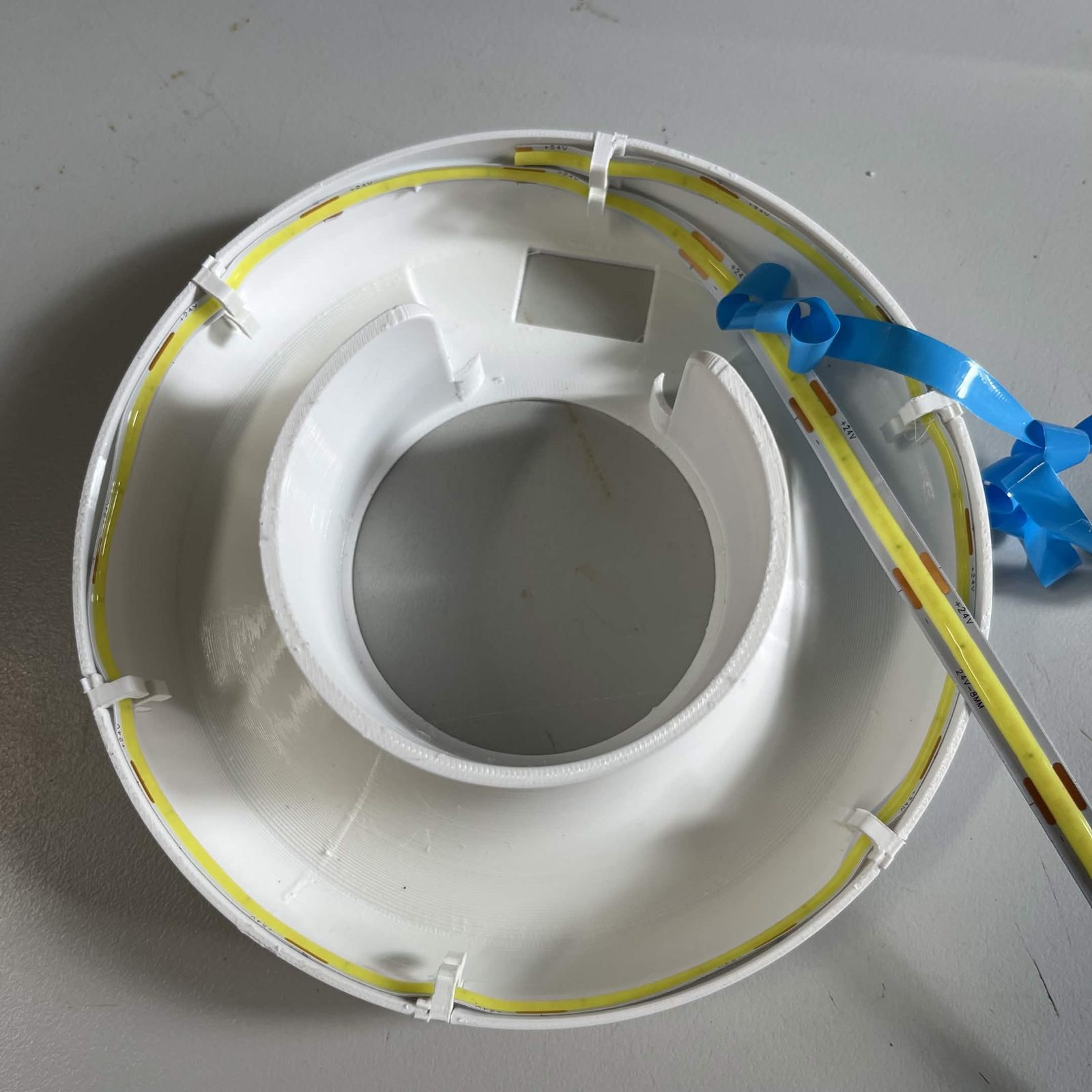 The strip run once around the inside of the reflector skirt, back at its starting point, with the blue film being peeled off the length still to go