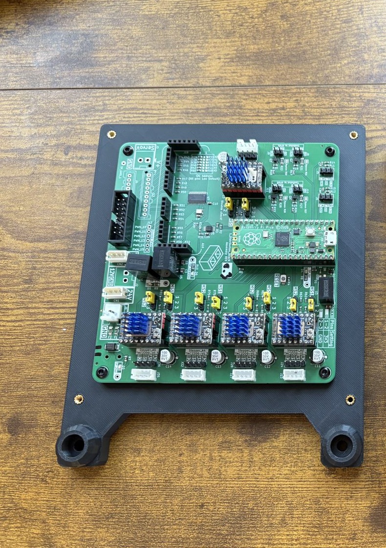 The populated control board screwed flat onto the printed base, its two extrusion clamp bosses at the bottom edge
