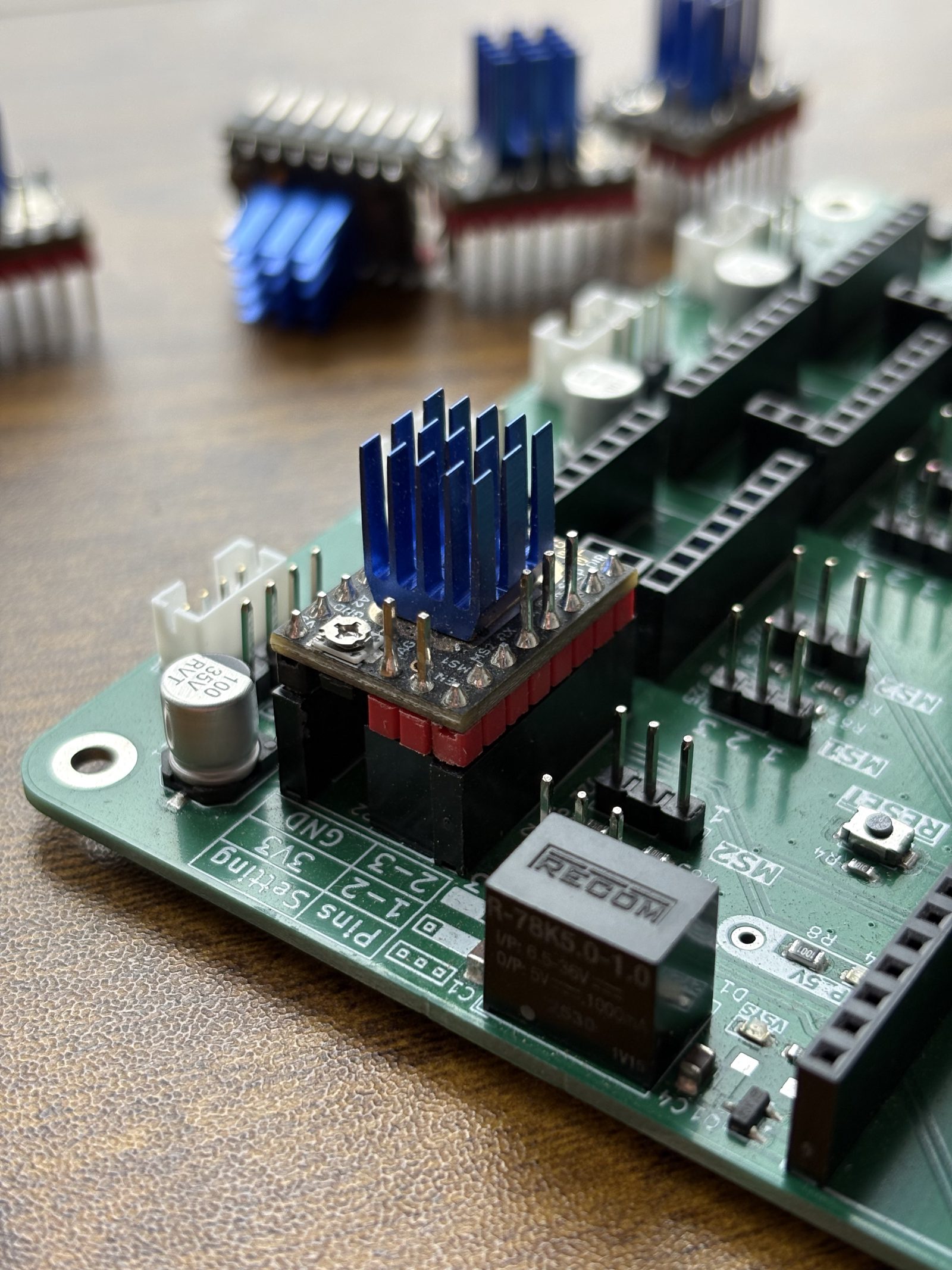 A TMC2209 driver pushed fully down into its socket on the control board, heatsink upwards, with the remaining drivers out of focus behind