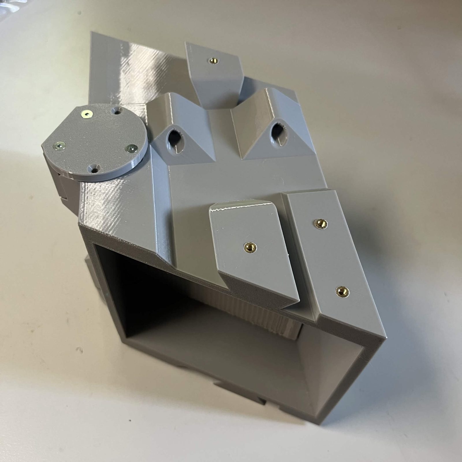The flap bolted to the core, seen down onto the top face, with the door closed so no blade shows below the core