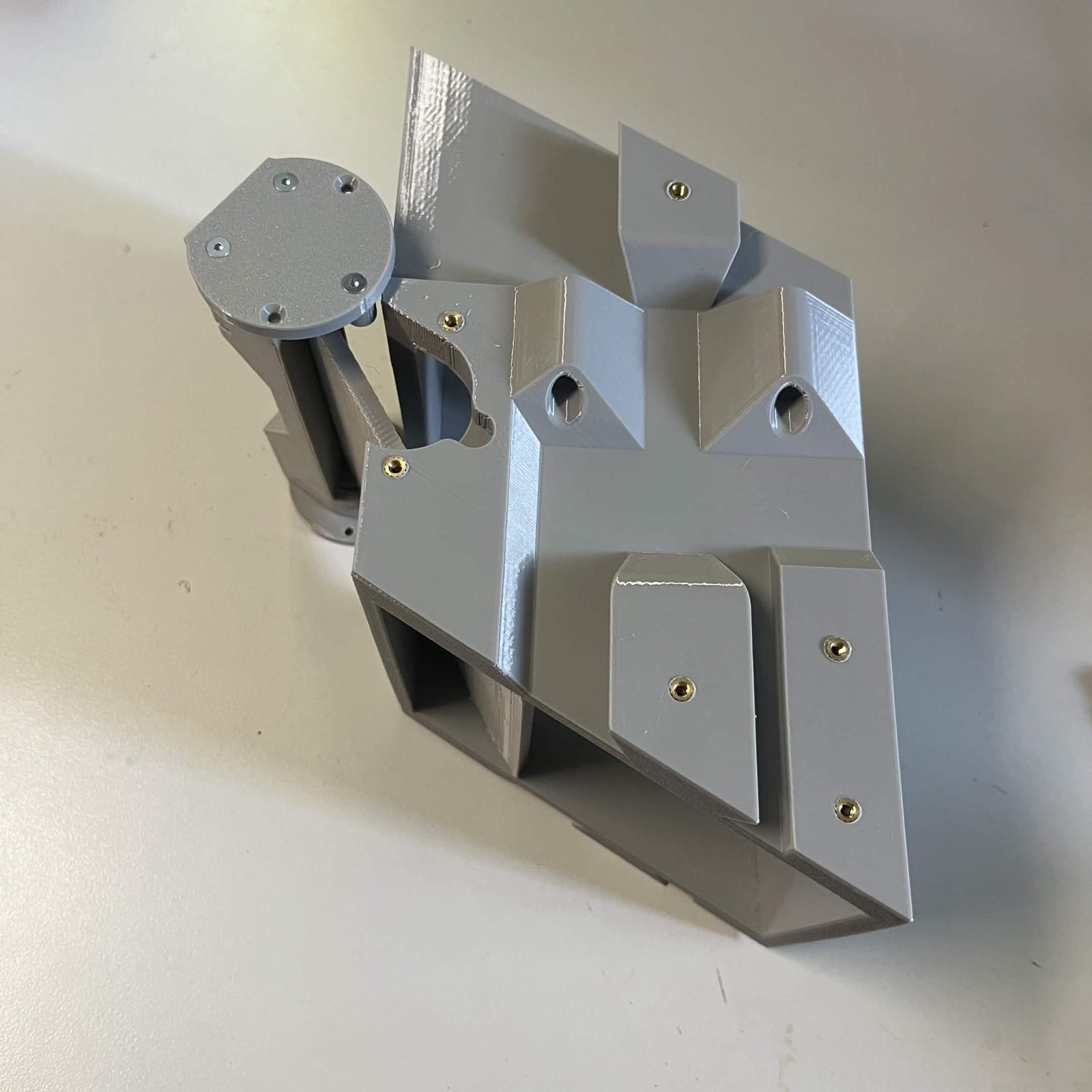 The flap assembly being offered up to the chute core, one bearing cover standing proud of the core's long side before its screws go in