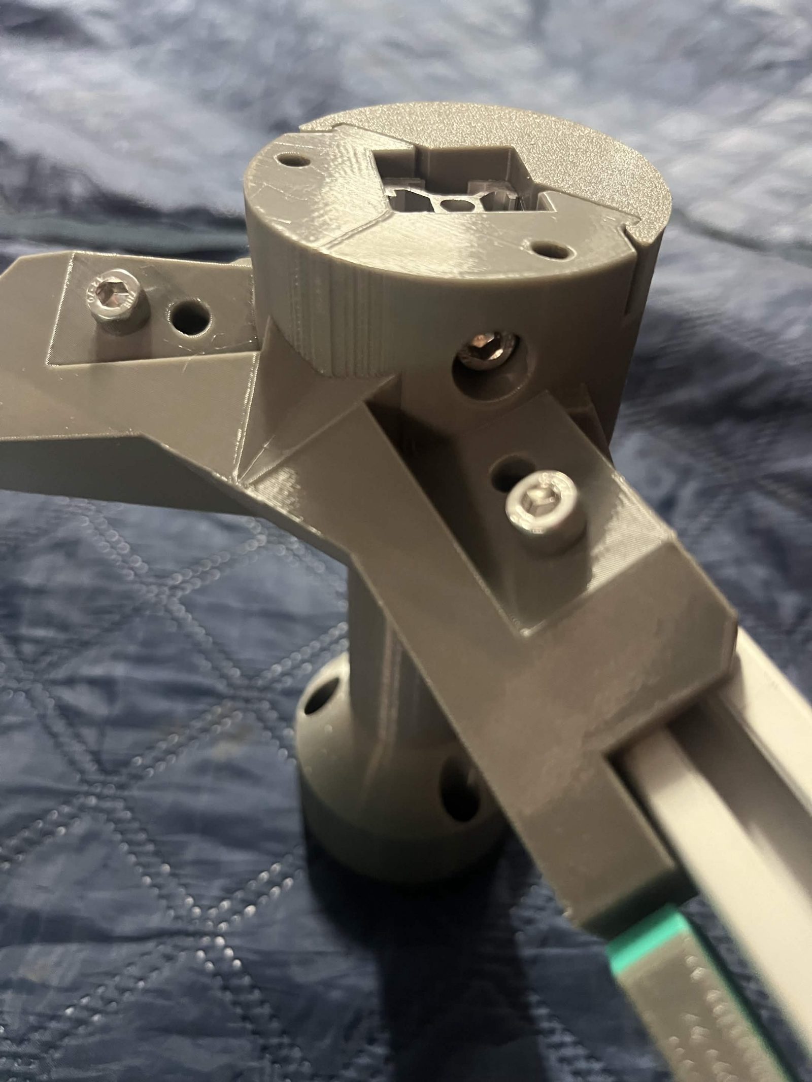 A layer corner seen from underneath: the end of piece C sitting below the rim of the collar, with the bracket's screws in their holes and the External bracket — bottom vertical tube below