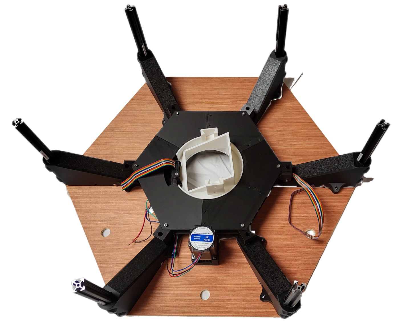 Six vertical extrusion supports bolted into the interface brackets, seen from above on the hexagonal top plate