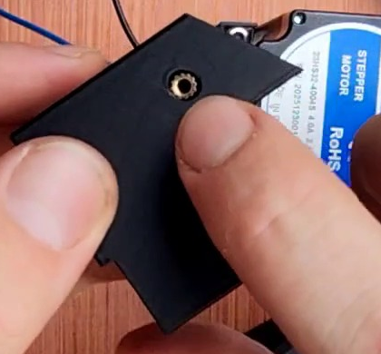 The Cable cage bracket (cable mount) held up, showing a single brass M3 heat insert