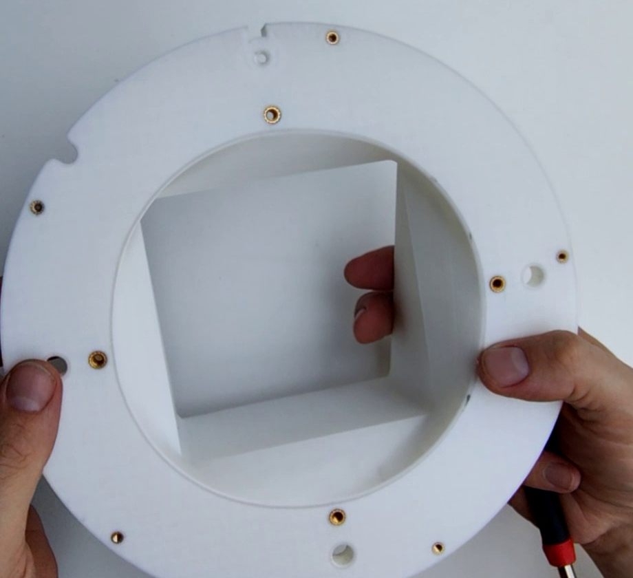 The underside of the white Top interface chute mount, showing brass M4 and M3 heat inserts around the ring