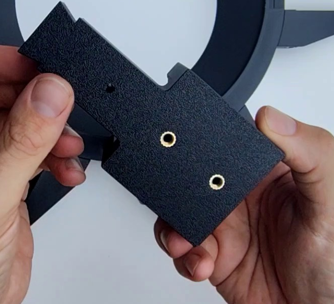 The underside of the Interface NEMA 23 bracket, showing the two remaining brass M5 heat inserts