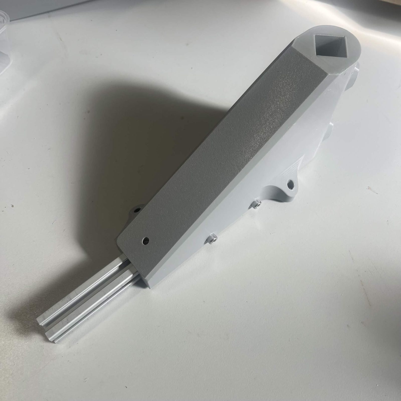 The joined Interface bracket and extrusion from the outer side, the extrusion projecting past the bracket's lower end and the square socket for the vertical leg at the top