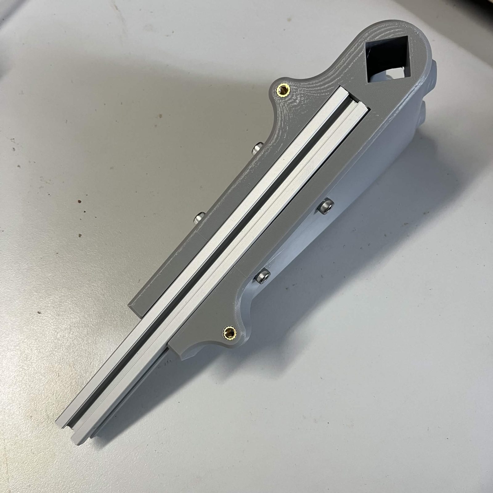 The extrusion slid into the Interface bracket's channel, with the four M5 screws driven into the T-nuts along the bracket's face and a brass M5 insert at each end of it