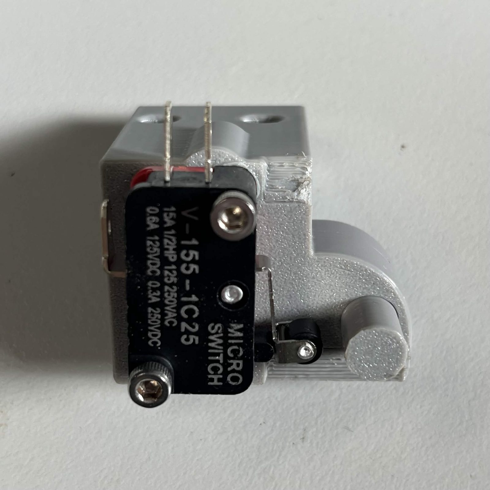 The roller lever limit switch screwed to the grey Limit switch housing, its roller sitting alongside the printed dowel pin