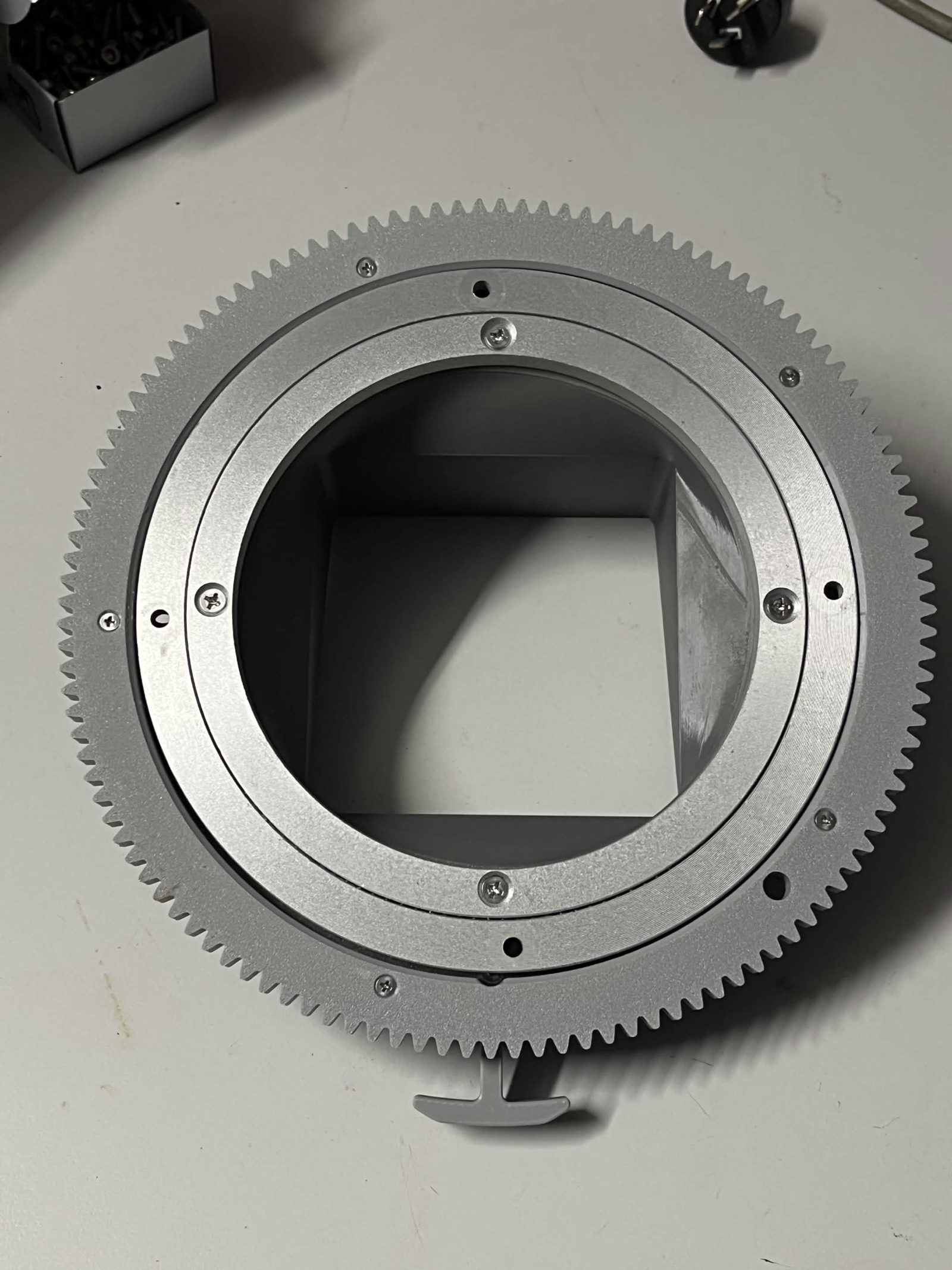 Gear side of the assembled Top interface chute mount, showing the chute gear, Lazy Susan, and Limit switch hammer