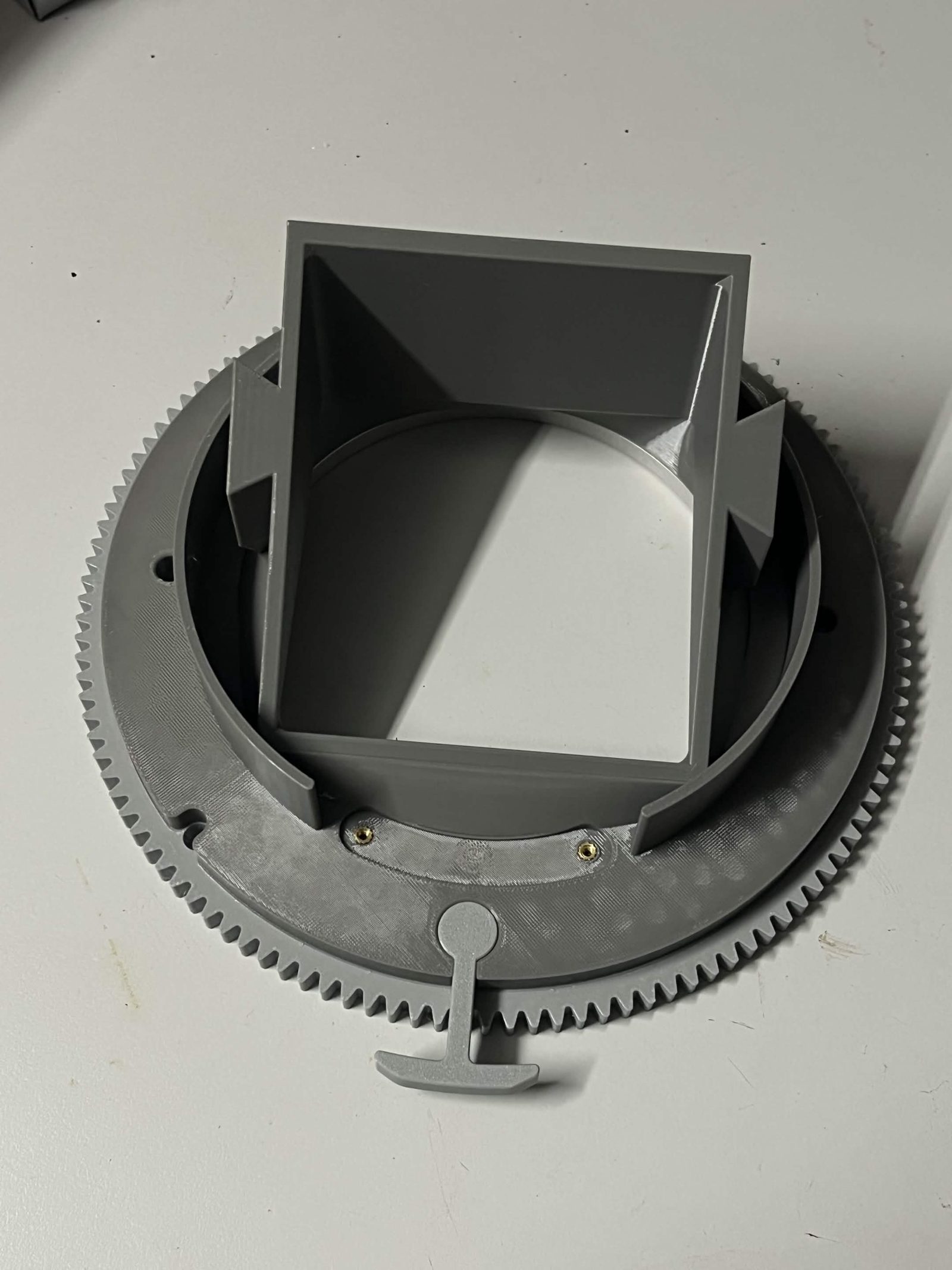Chute side of the assembled Top interface chute mount with the Limit switch hammer extending from the edge