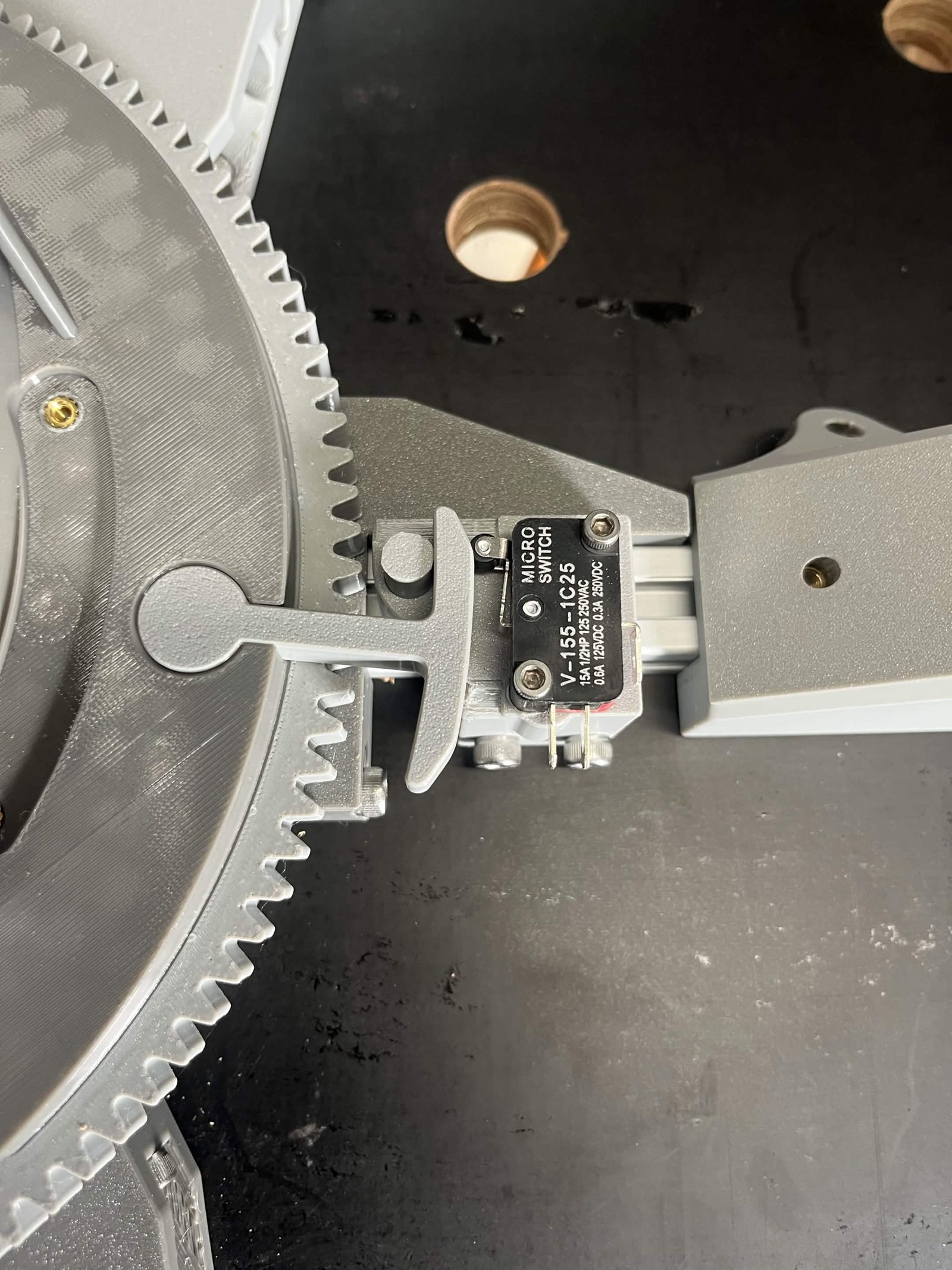 Looking straight down on the ring gear and the limit switch housing: the hammer swung in towards the roller lever of the microswitch, with a clear gap between the hammer and the printed dowel pin beside it