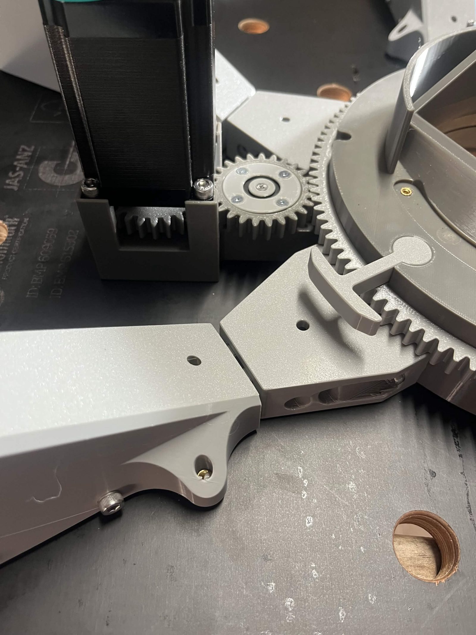 The NEMA 23 stepper motor installed, its spur gear meshed with the idler gear and the chute's ring gear