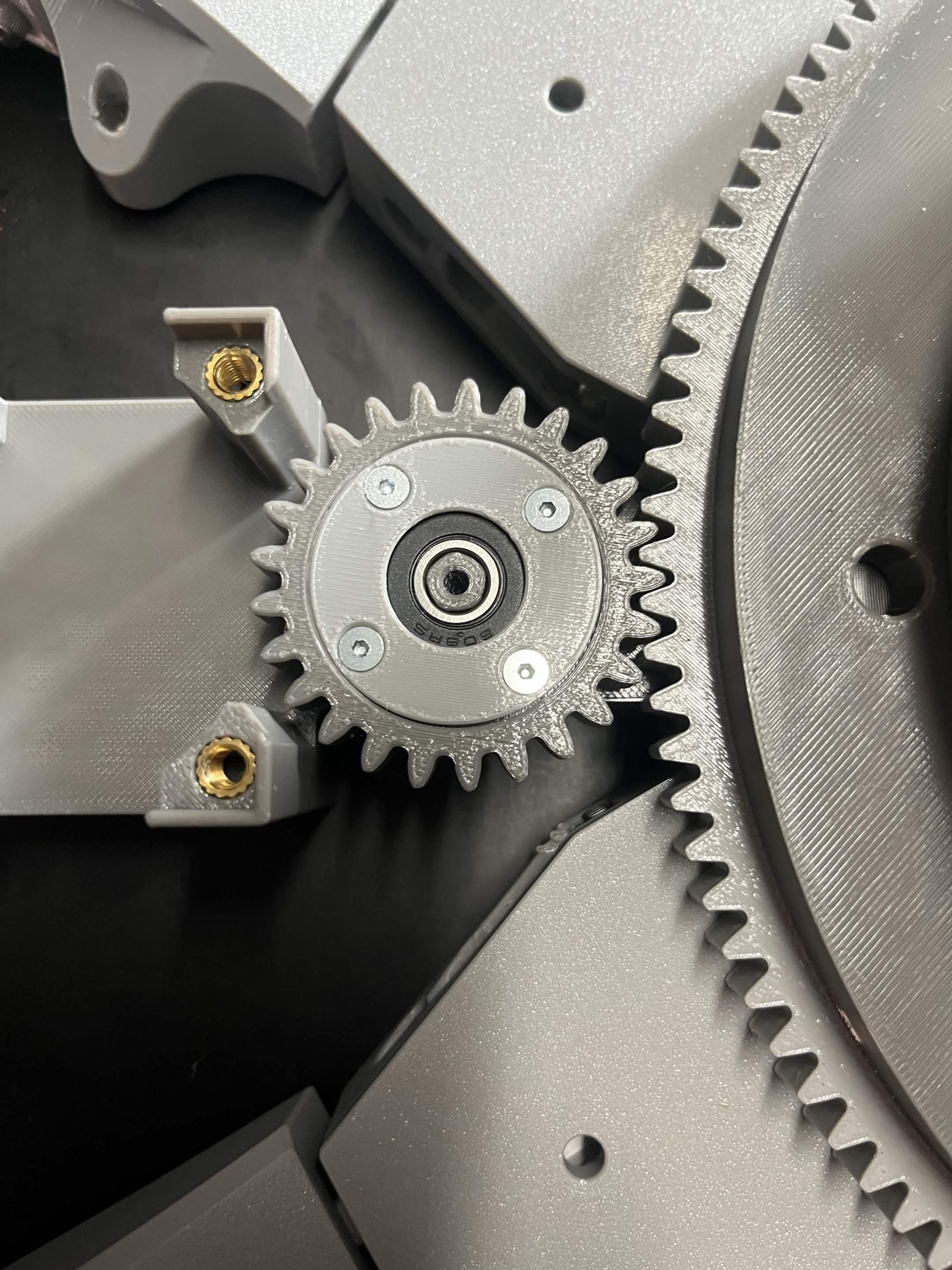 The Interface idler gear pushed onto the NEMA 23 bracket and meshed with the chute's ring gear, its bearing bore still open with no screw through it