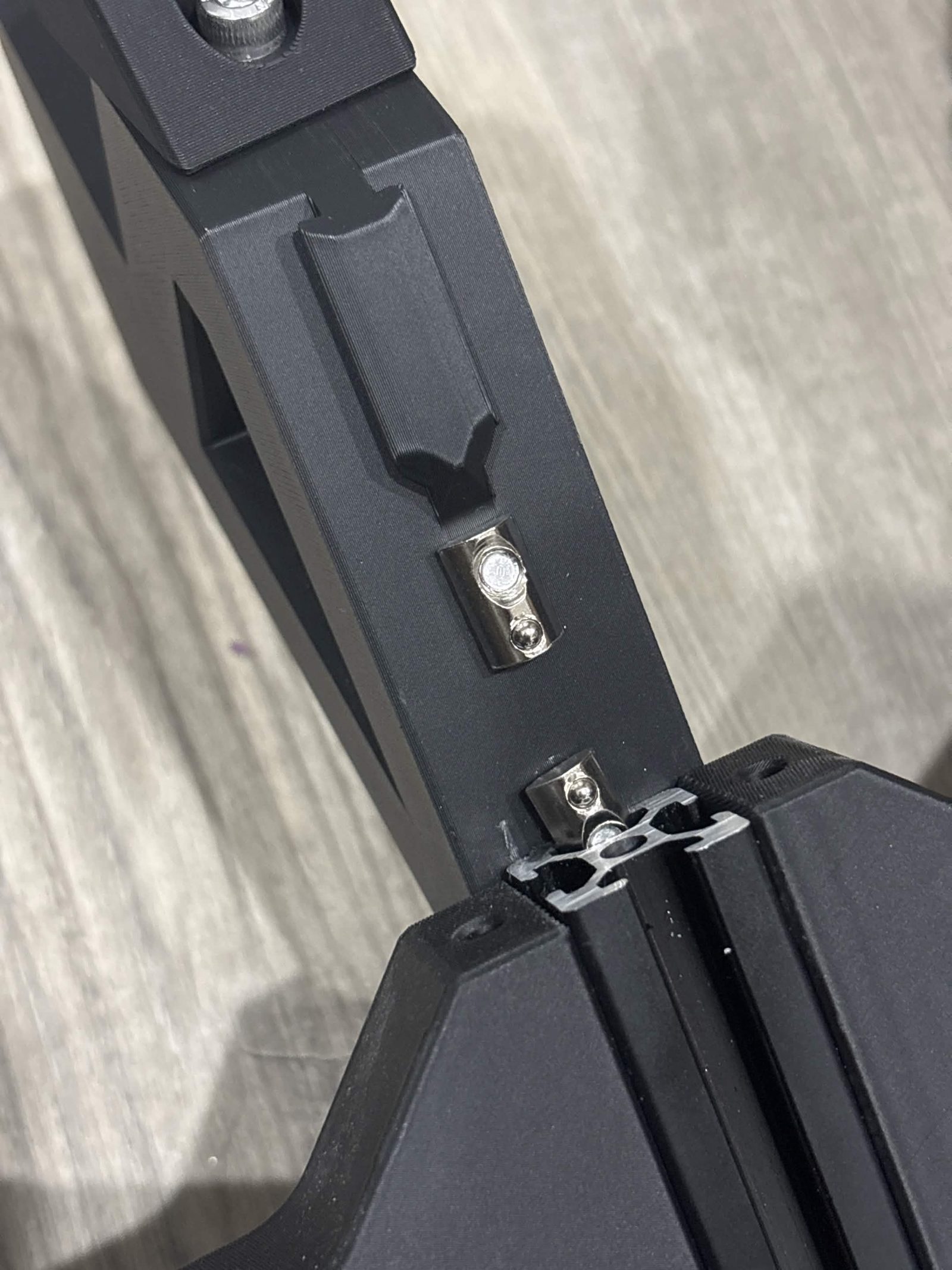 Close view of the two prestarted T-nuts lined up with the open end of the 2020 extrusion slot on the spoke