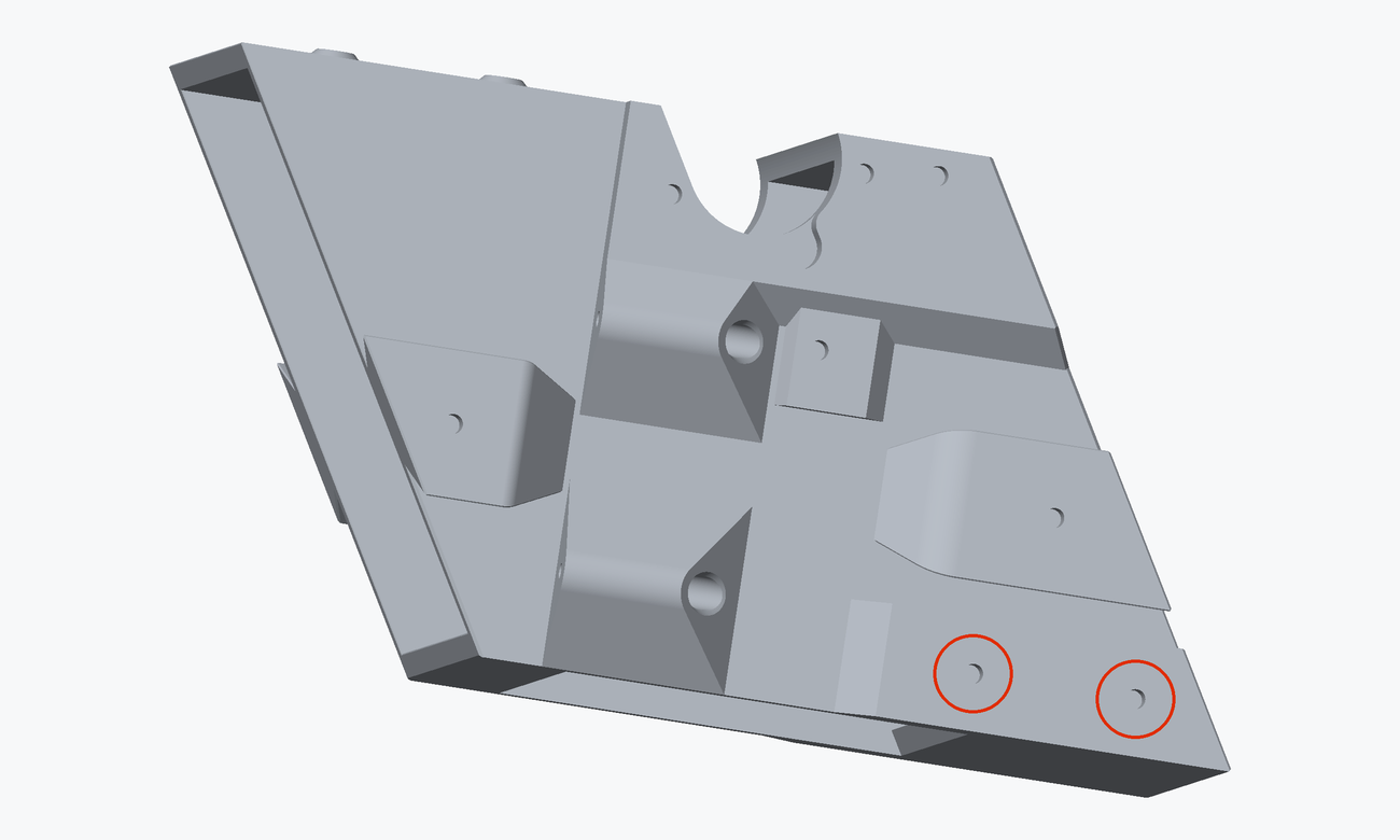 Render of one long side of the chute core with the two heat inserts a funnel bracket screws into circled in red