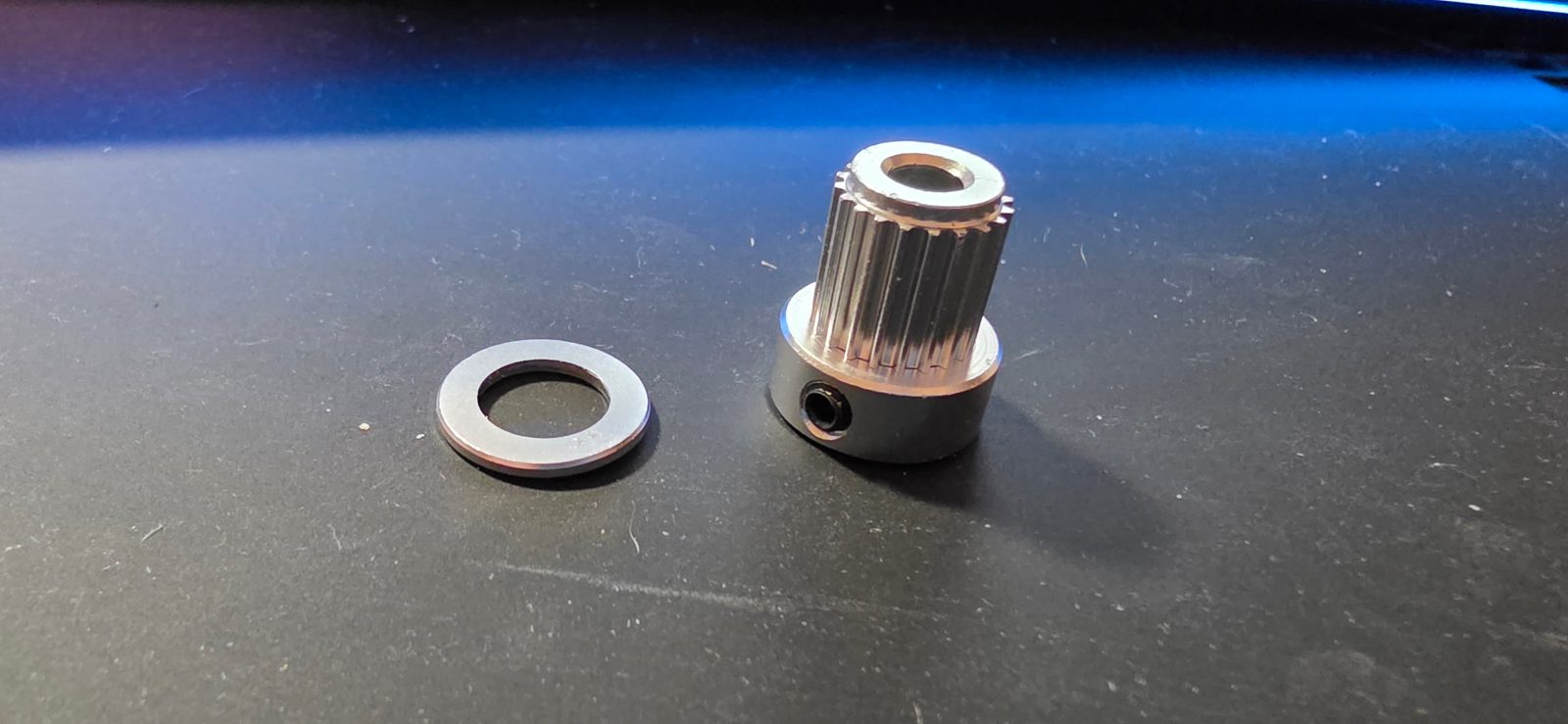 20-tooth timing pulley after preparation, with the removed top flange beside it