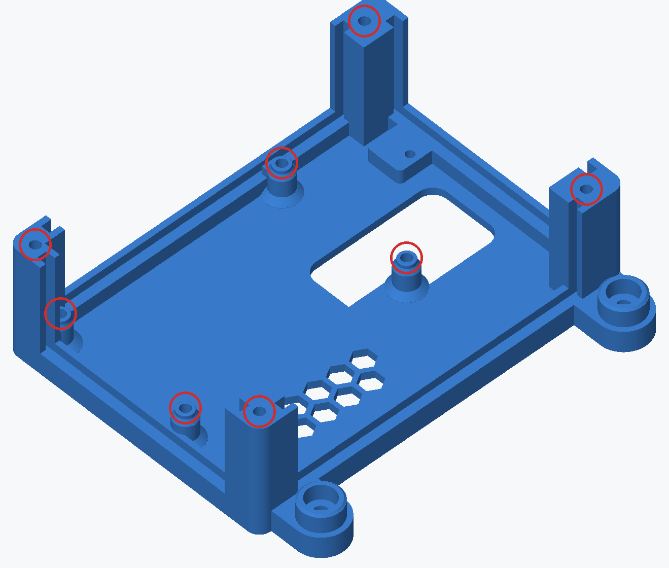 Render of the housing base on its own, seen from above and one end, with a red ring round each of the eight heat-insert bores: four in the low posts in the middle of the floor and four in the tops of the tall corner posts