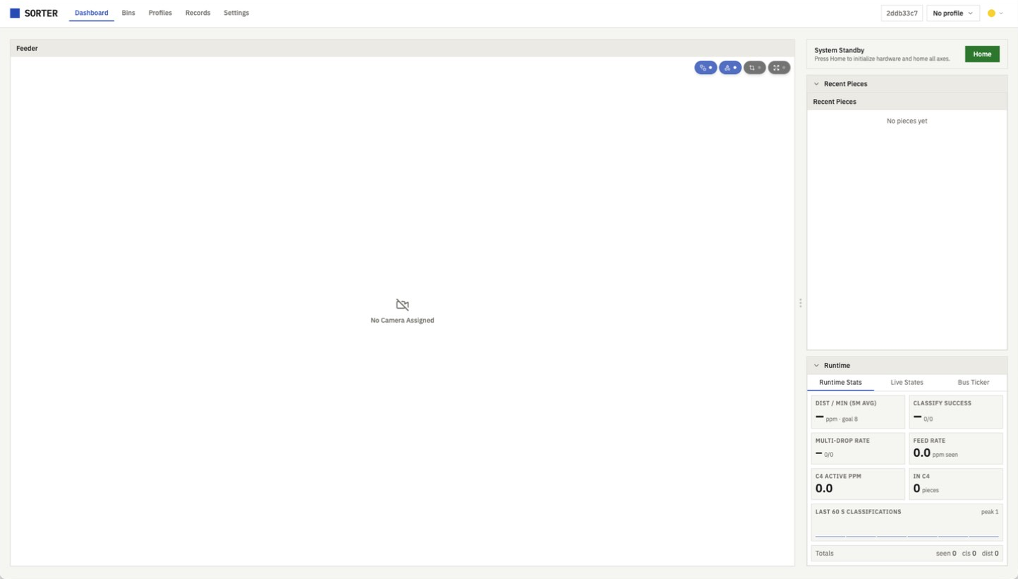 The SorterOS UI's dashboard the first time it loads: the Dashboard, Bins, Profiles, Records and Settings tabs along the top, a feeder panel reading No Camera Assigned, the machine in System Standby with a Home button, no pieces yet, and the runtime stats all at zero.