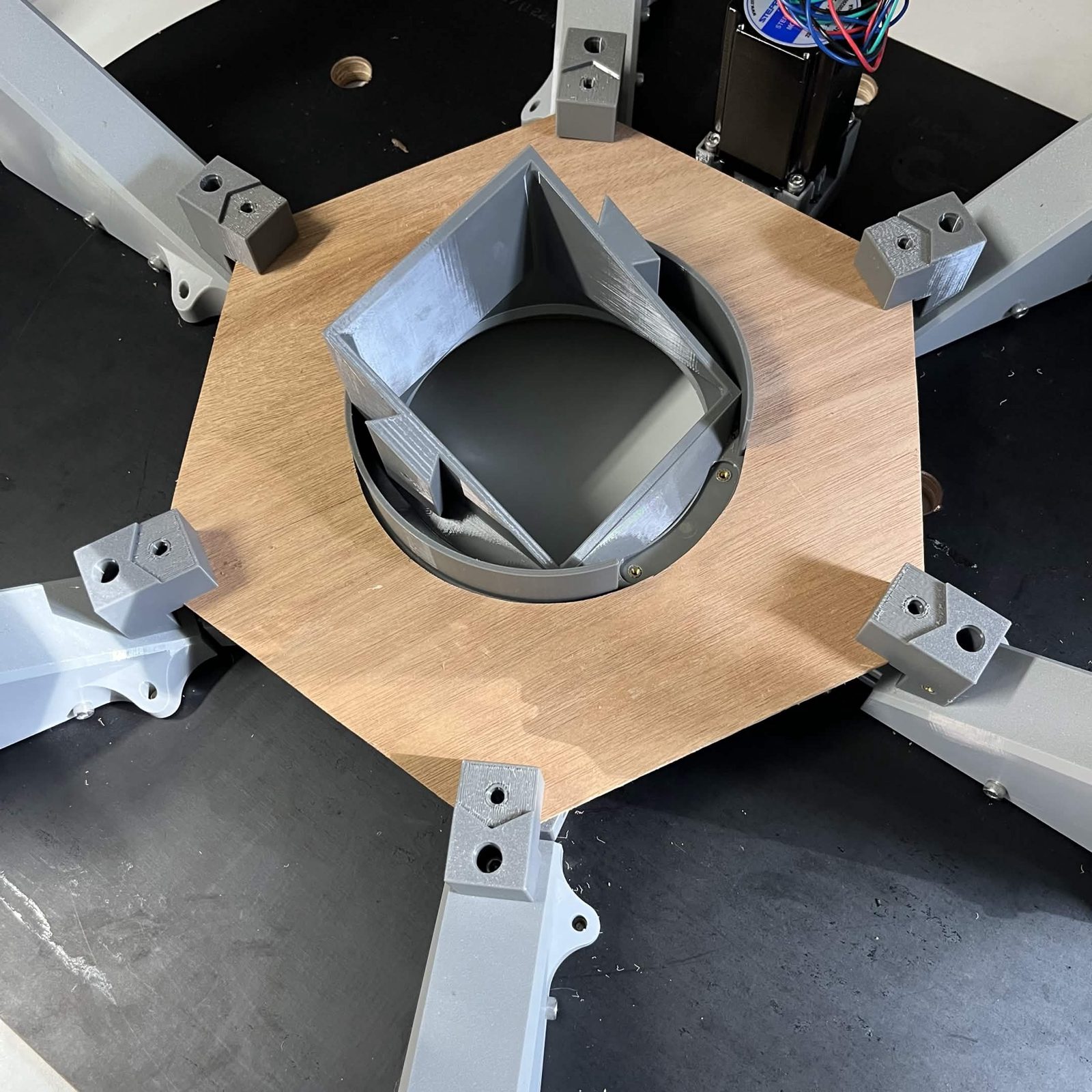 The same plate from a lower angle, the round centre hole and the gap between it and the chute mount visible
