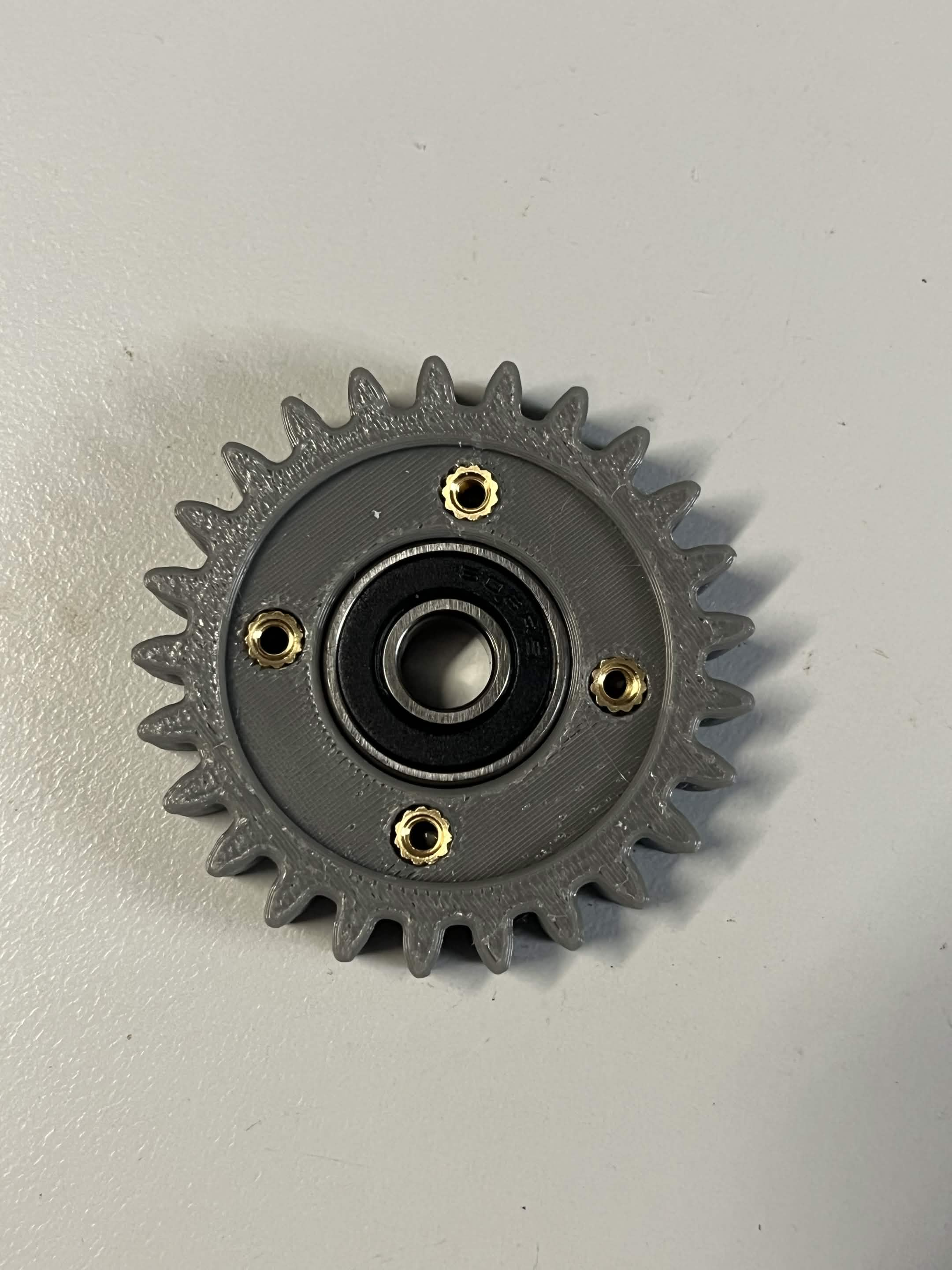 608 2RS bearing pressed into the centre of the grey Interface idler gear, with the 4 brass M3 heat inserts visible around it, before the bearing retainer caps go on
