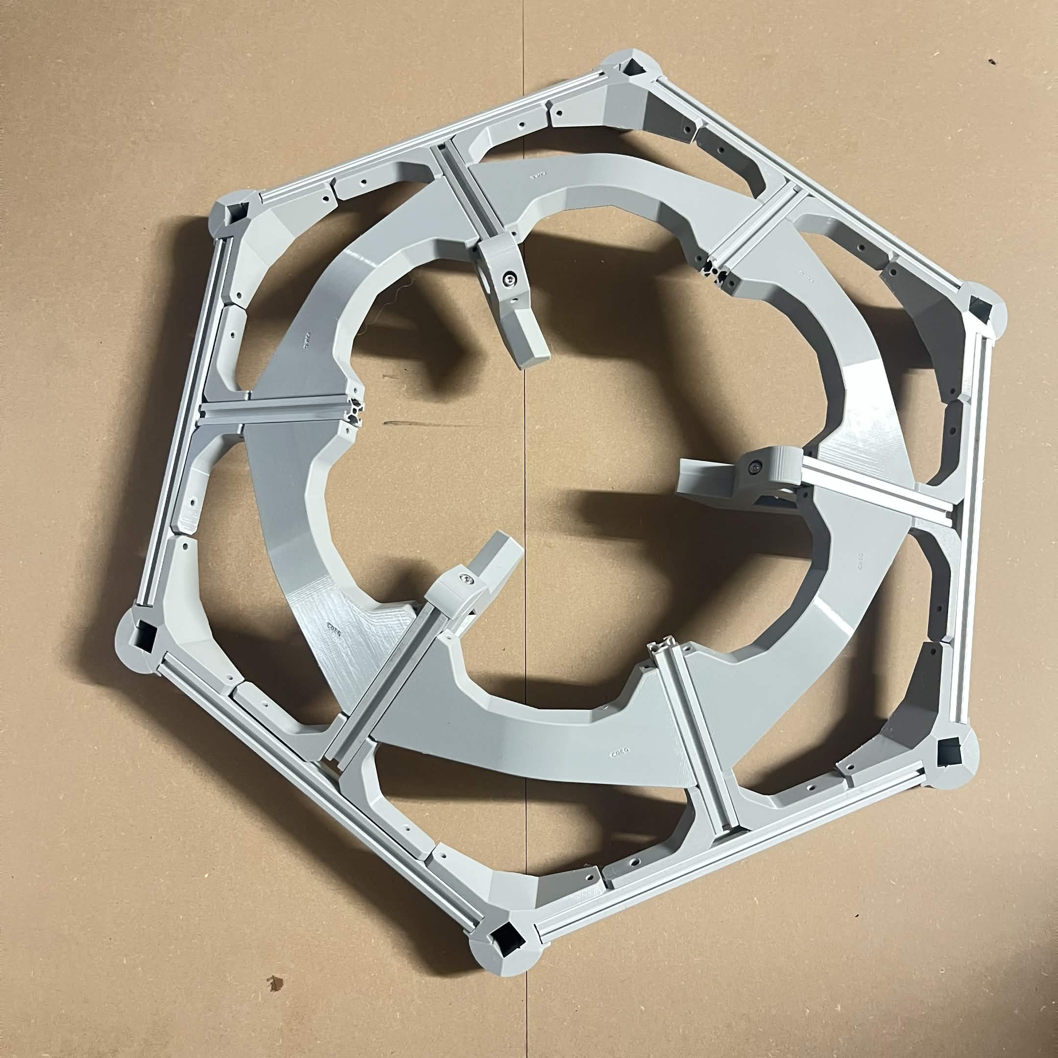 Top-down view of the assembled hexagonal layer frame with three Lazy Susan extrusion mounts fitted at alternating spokes