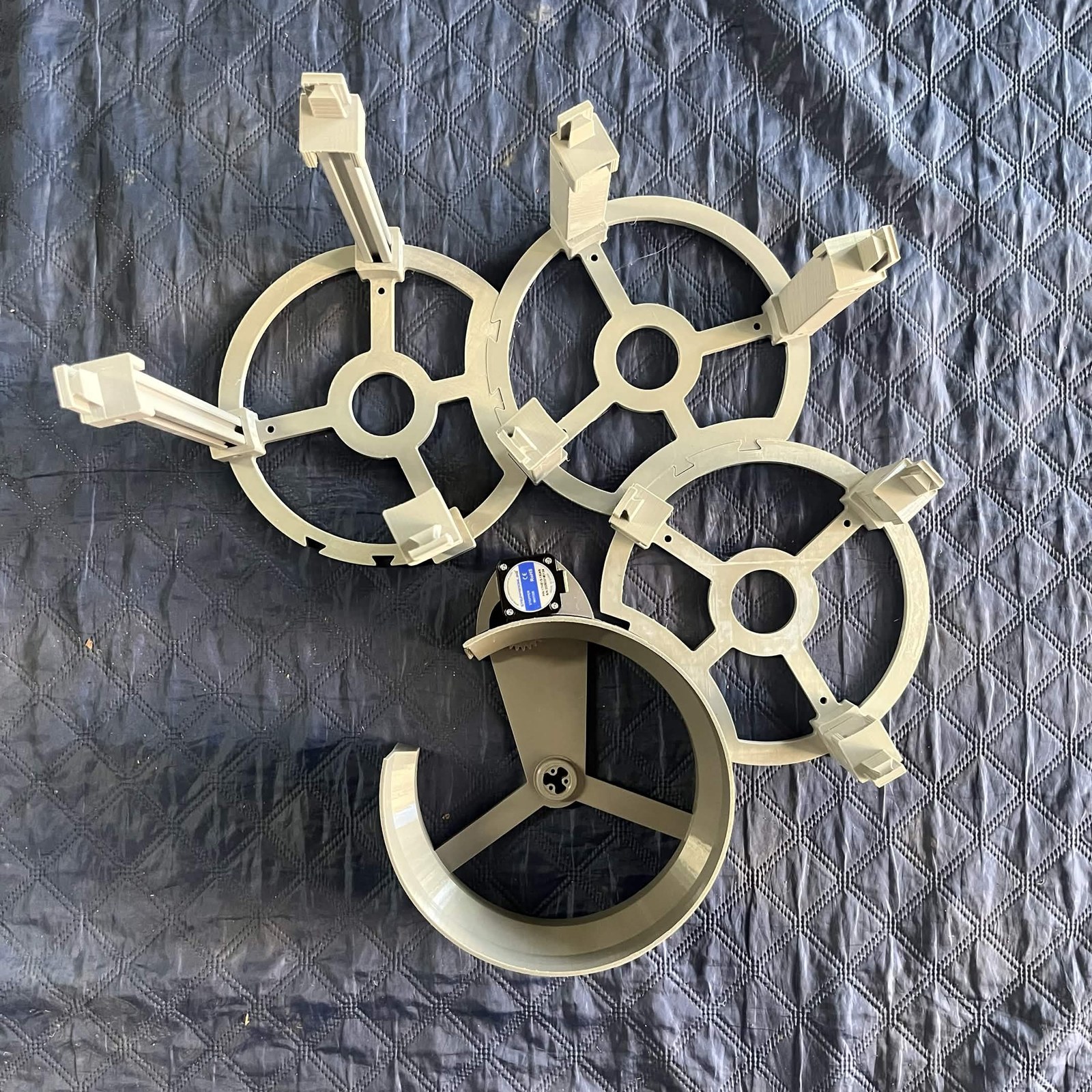 The classification channel's drive, stator ring with its stepper motor on the bracket, slid onto the layout guide that C3 stands in, with the three stands lying around it