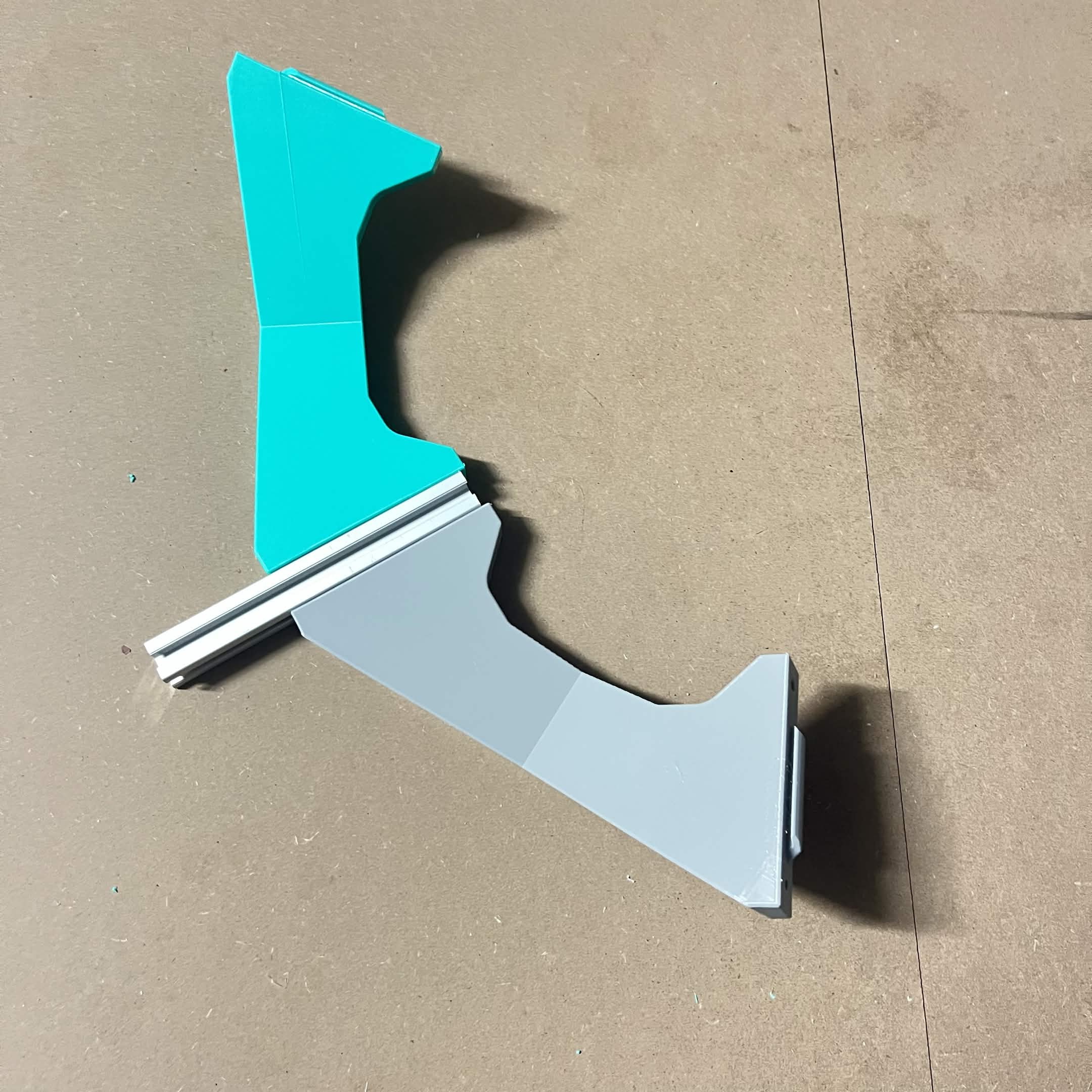 A grey B spoke and a teal Frame crossbeam slid together over a length of aluminum extrusion, the crossbeam upside down