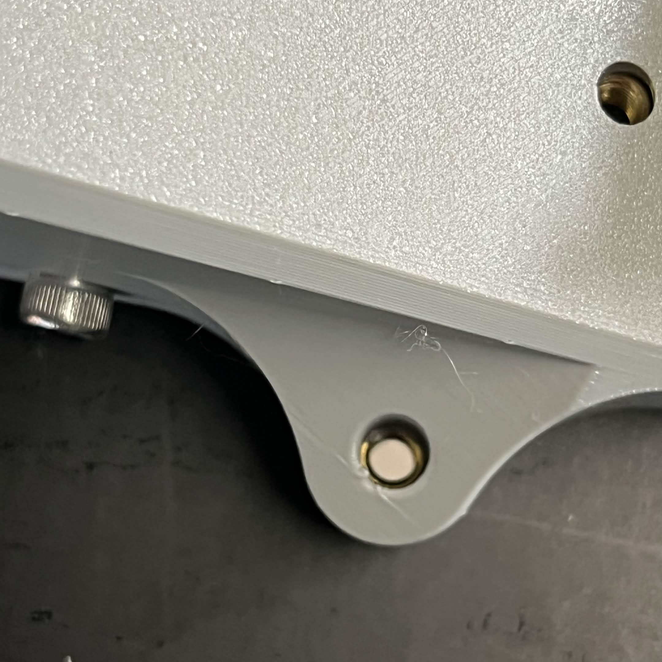 Looking down through one of the Top plate's screw holes, with light visible through it into the extrusion channel below