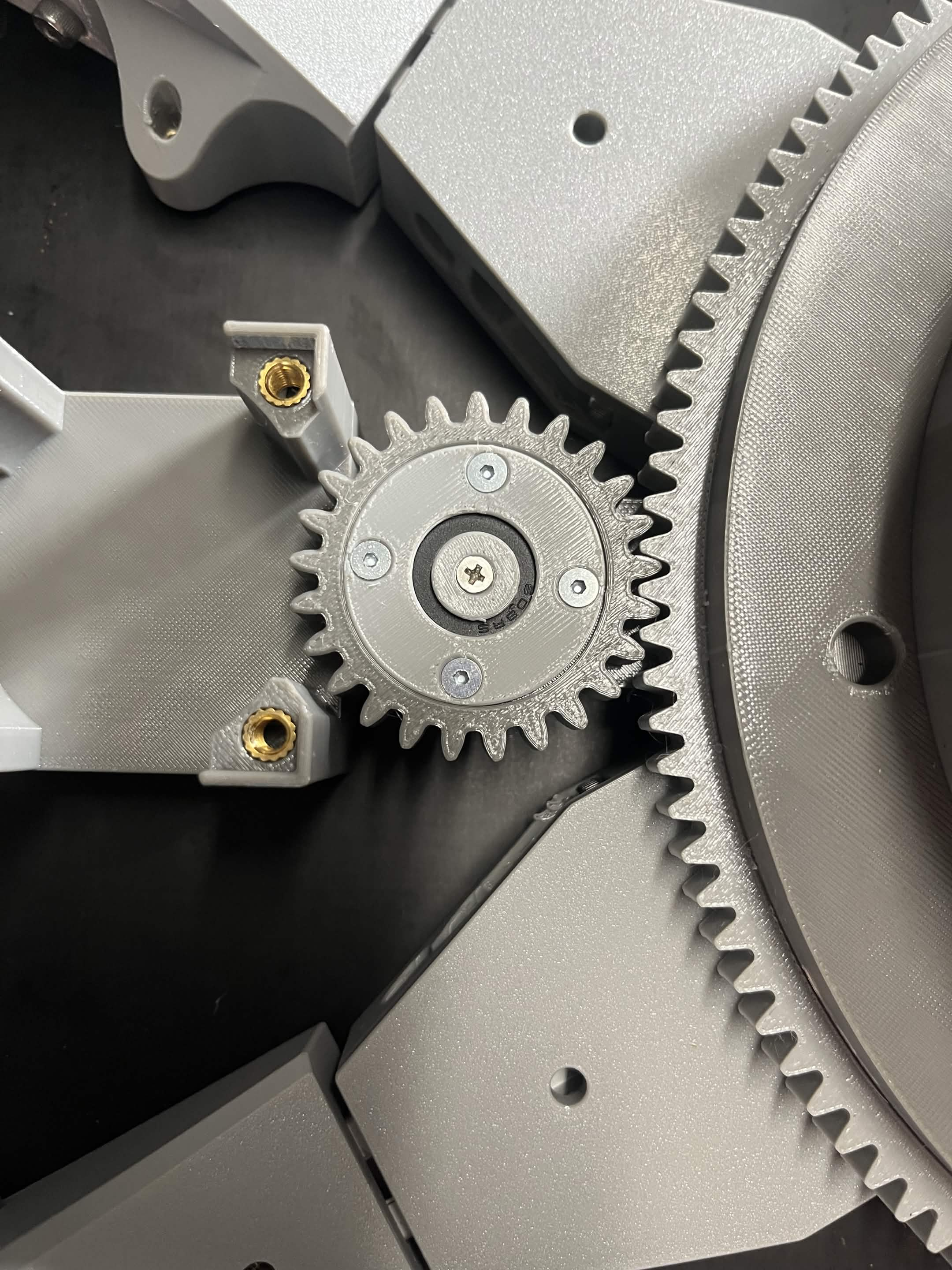 The Interface idler gear on the NEMA 23 bracket with the outer retainer over its bearing and a countersunk screw driven flush through the middle of it